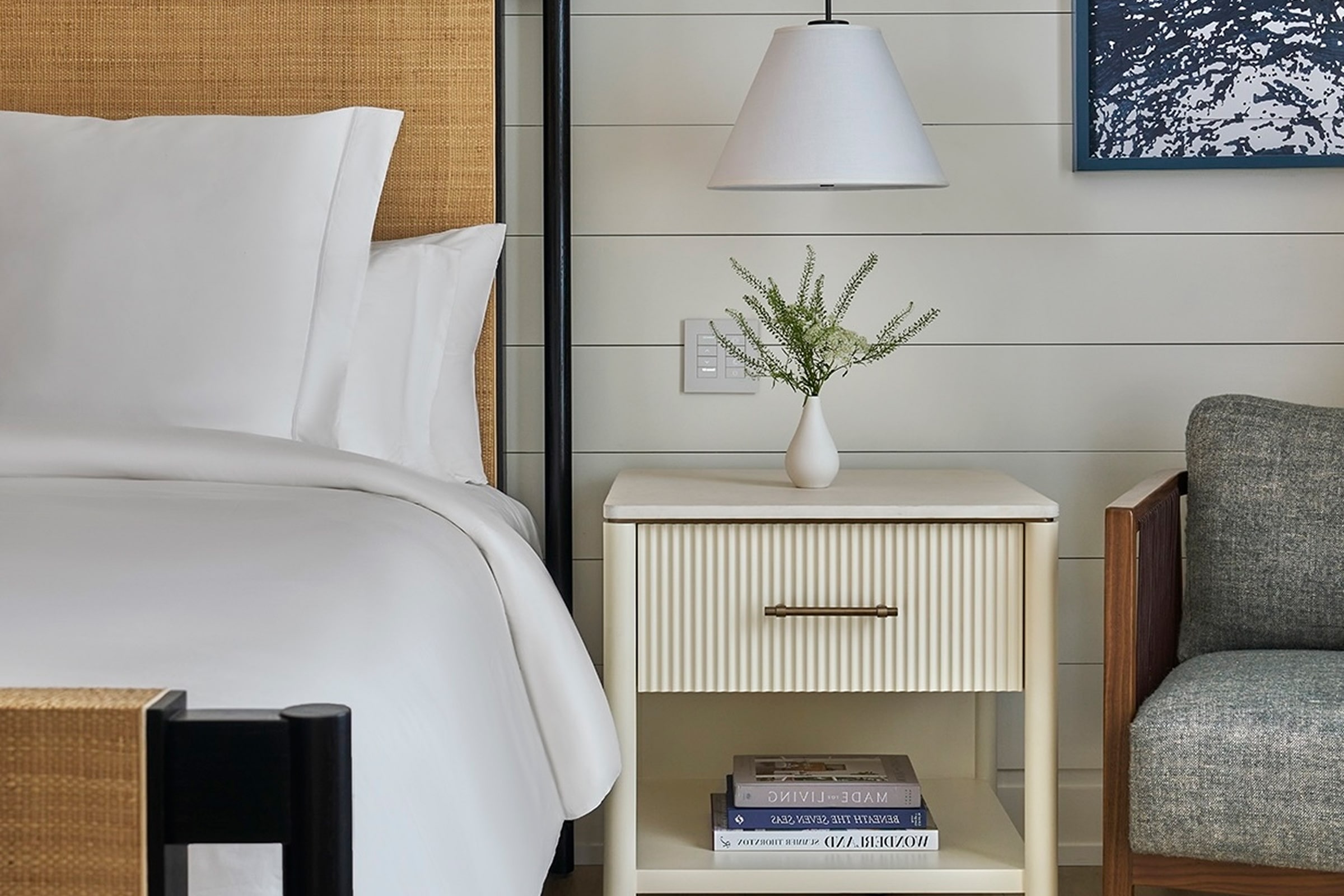 this image depicts a hotel bedroom with a freshly made bed