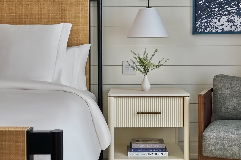 this image depicts a hotel bedroom with a freshly made bed