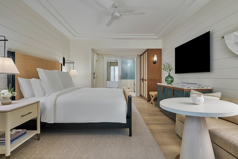 this image depicts a hotel bedroom with a freshly made bed