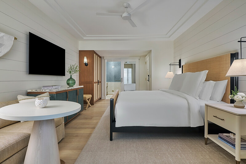 this image depicts a hotel bedroom with a freshly made bed