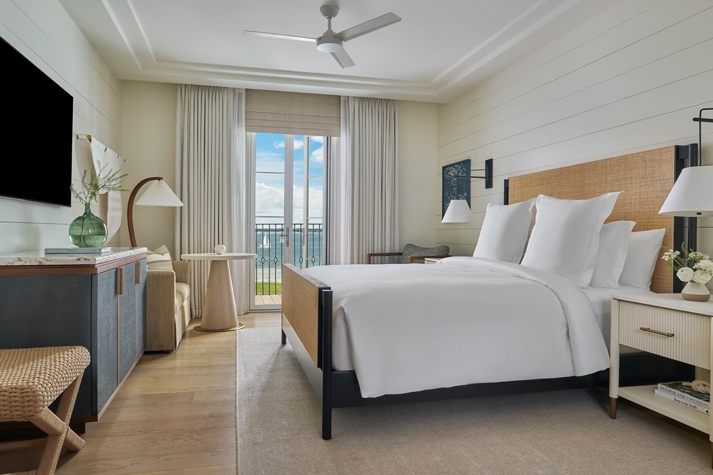 this image depicts a hotel bedroom with a freshly made bed